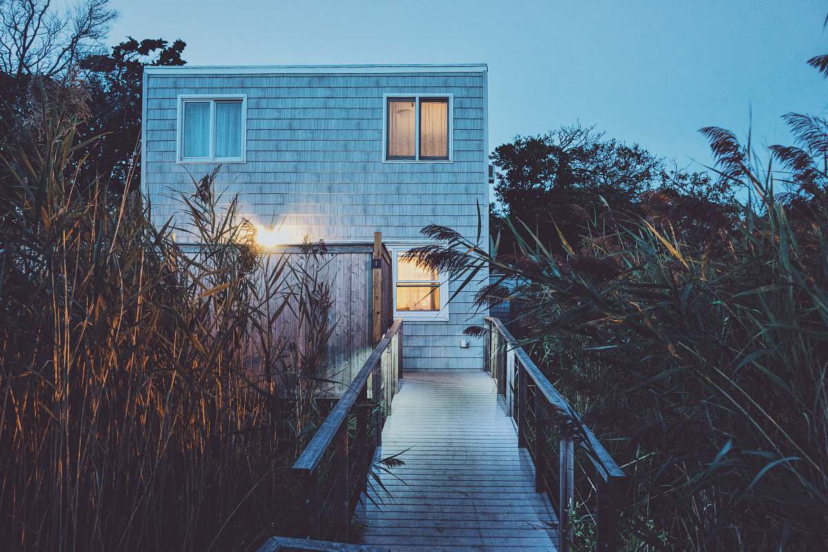 fire island white painted house with turned on light boardwalk